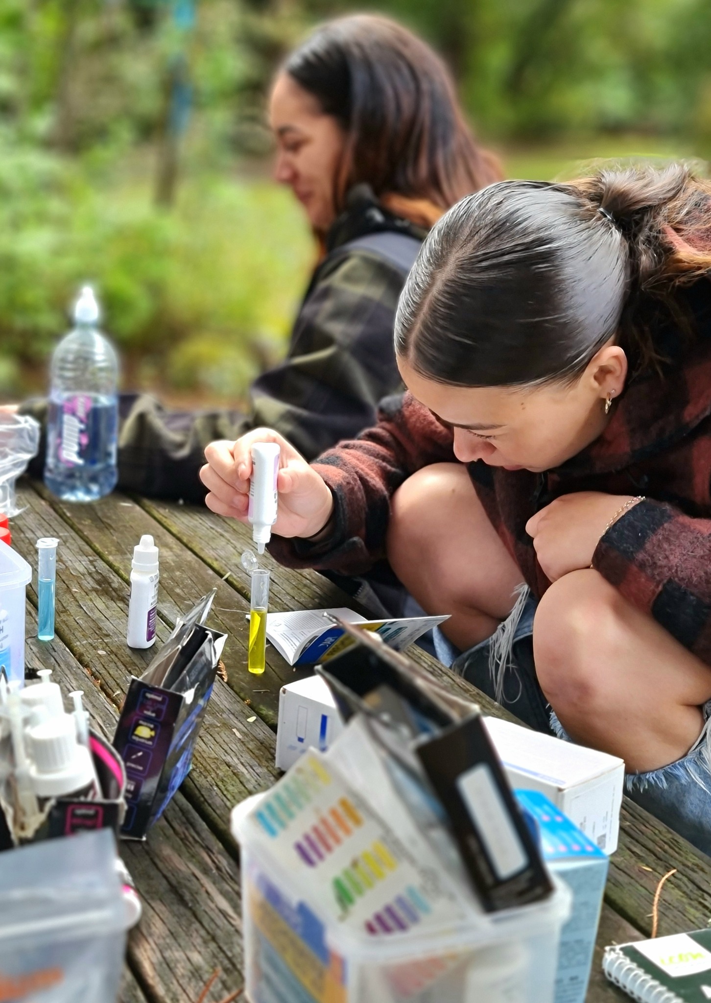 A person testing water in an aquaponics system.